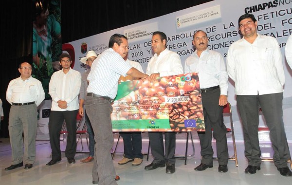 Eduardo Ramírez entregando a cafeticultores un cheque de papel. Foto: Archivo