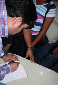 El momento en que maestros de la CNTE hacen firmar a Pedro León Toro, director de la Policía Especializada de la PGJE, para constatar que recibió a los agentes de inteligencia sin lesiones y todas sus pertenencias. Foto: Isaín Mandujano/Chiapas PARALELO