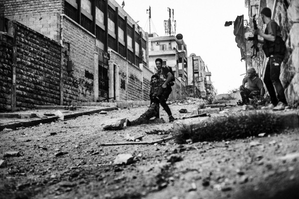 Miembro del FSA ayuda a un compañero herido por el disparo de un francotirador del ejercito Sirio en el barrio de Izaa, Alepo, Siria. Sep. 2012 ©Manu Brabo