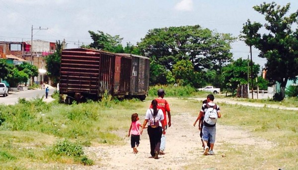 Con hambre, familias completas caminan en la vía del tren en Arriaga, Chiapas, esperando la salida del tren. 