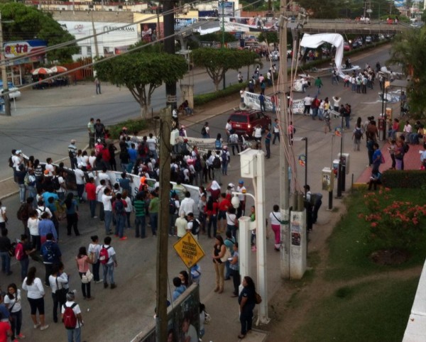 Retiran publicidad durante la marcha los estudiantes normalistas. Foto: Sandra de los Santos/ Chiapas PARALELO. 