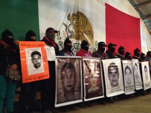 Zapatistas sostienen las lonas con los rostros de los desaparecidos. Foto: Frayba