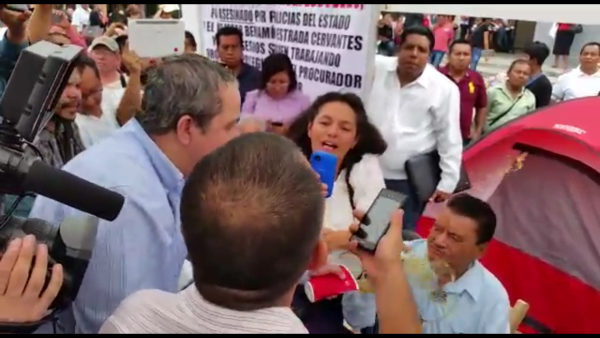 El momento en que al abogado y activista le es arrojado orines con un vaso. 