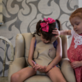 Valentina, de 2 años, consuela a su hermana Graciela mientras pasa por una de sus convulsiones en la sala de su casa en Monterrey (Adriana Zehbrauskas / Para The Washington Post).