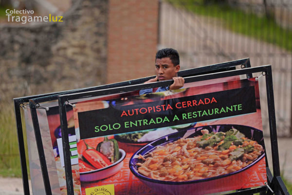 "Al final del día". Un empleado recoge la publicidad del restaurante donde labora.