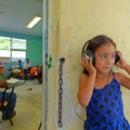 una niña escucha la grabación en vivo de una de las mesas de trabajo en el ejido Francisco I. Madero