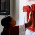 Antonia Hernández mostrando un huipil hecho por ella, a su nieta María Santis, en el marco de la inauguración de la exposición Guía Textil de los Altos de Chiapas: San Andrés Larráinzar. Cortesía: Carlos Barrera.