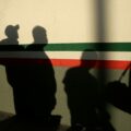 Mexican immigrants cast shadows on a National Institute of Migration (INM) building after they were deported from the United States and crossed the Paso del Norte border bridge amid the spread of the coronavirus disease (COVID-19), in Ciudad Juarez, Mexico April 21, 2020. REUTERS/Jose Luis Gonzalez