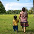 Abuela y nieta caminan por un pastizal cerca de Tapachula. Cortesía: OIM/Alejandro Cartagena 